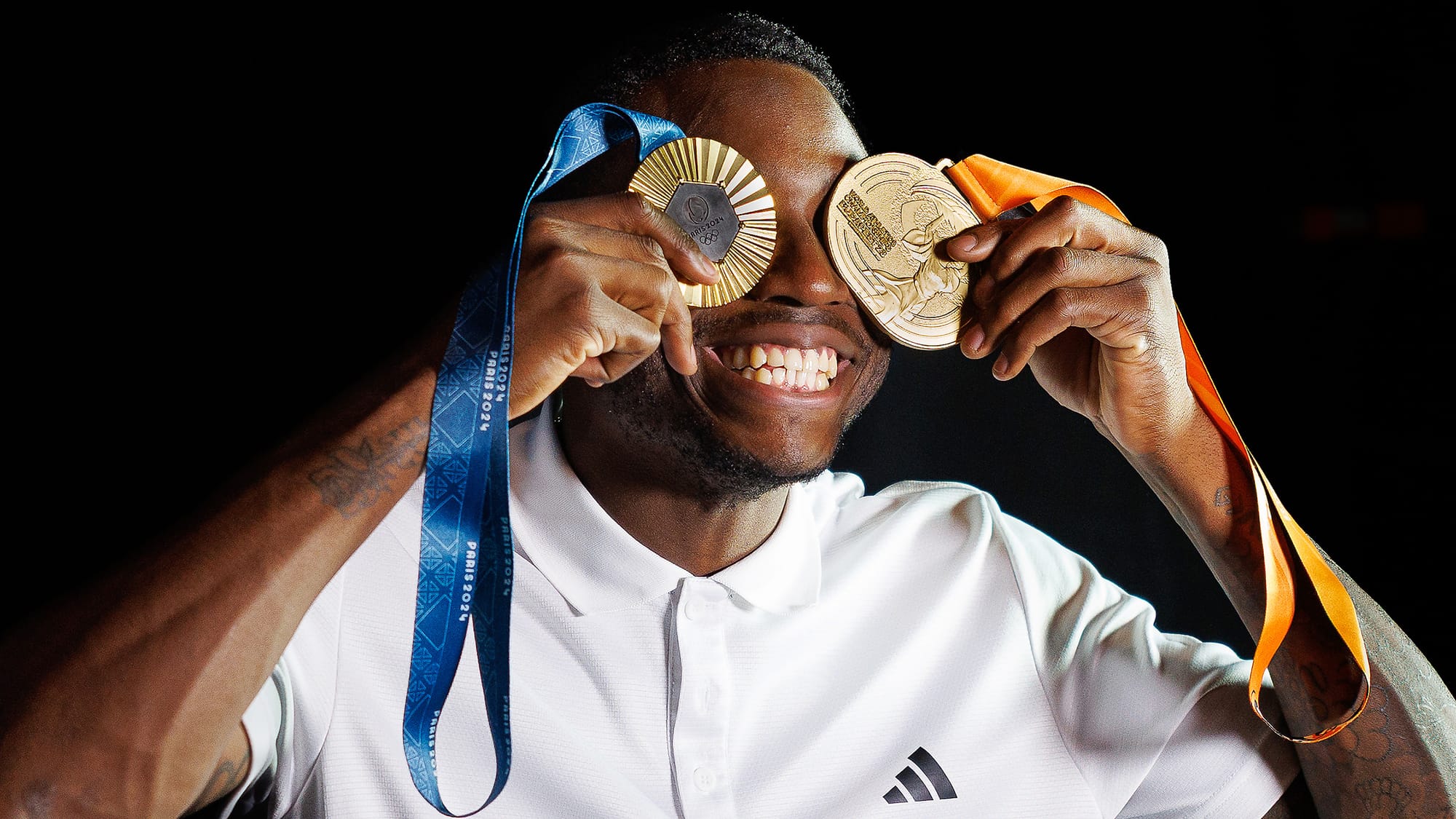 Grant Holloway poses with his 2024 Paris Olympics and 2023 World Championships 110-meter hurdles gold medals during a photoshoot in Weimer Hall at the University of Florida on Feb. 17, 2026.