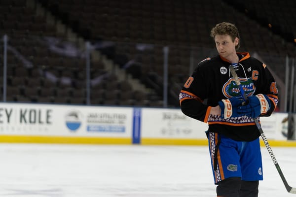 Dylan Morton puts on his gloves while skating for UF club hockey. 